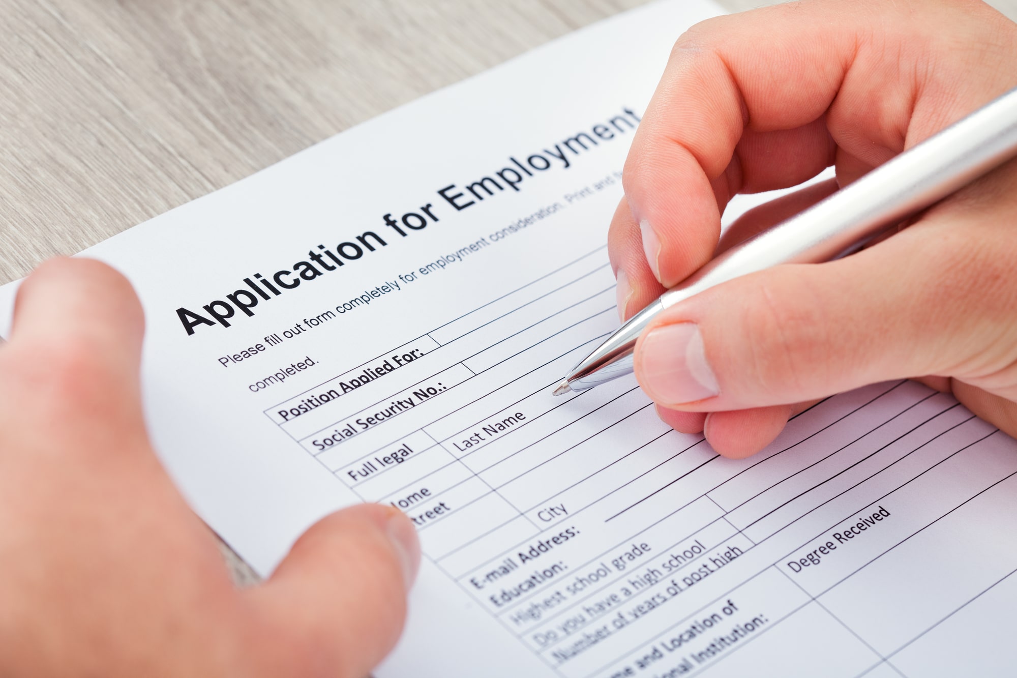 Photo of a person filling out an application for employment
