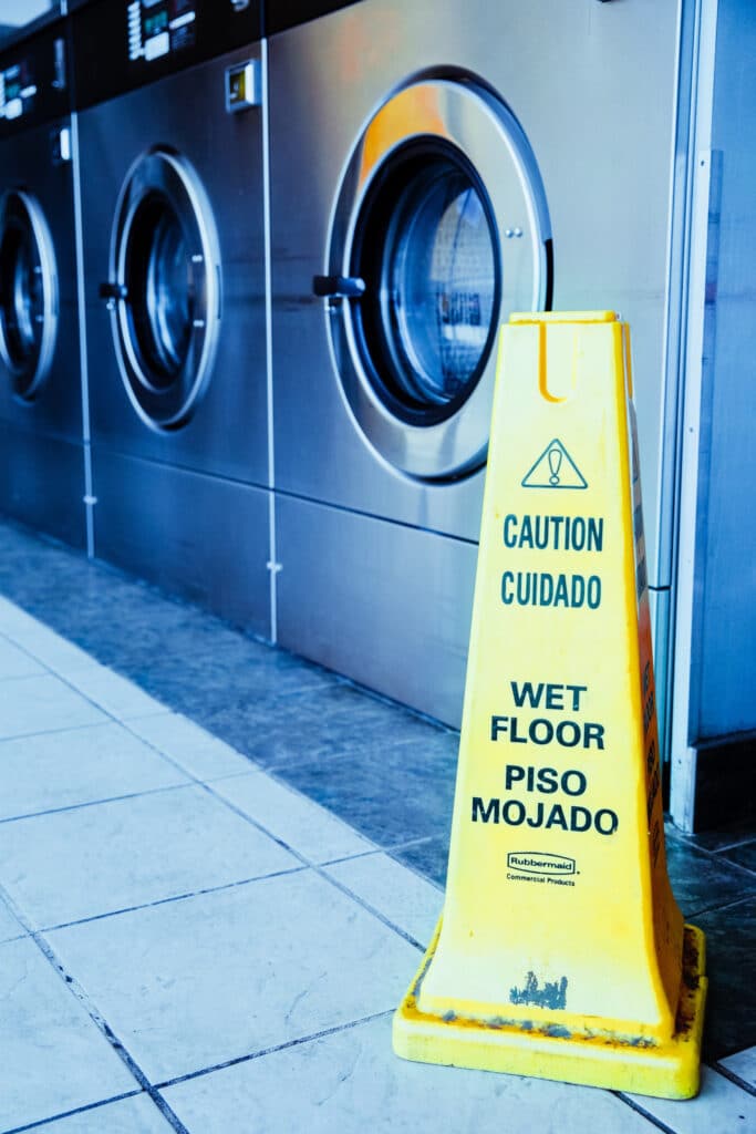 Washers behind a wet floor sign