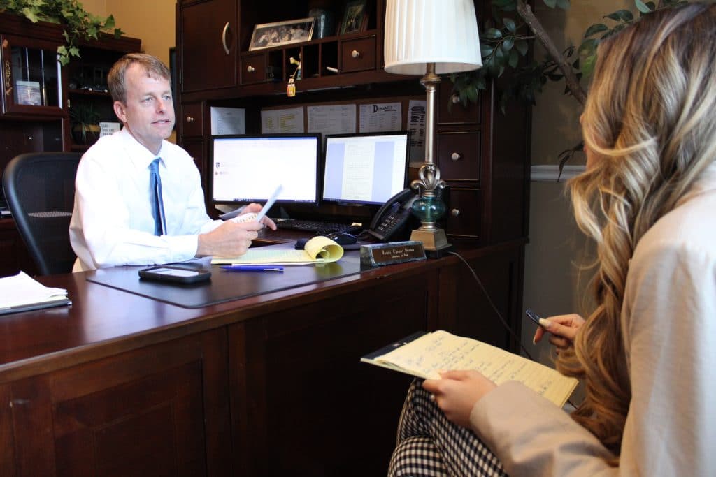 Personal injury attorney Jim Gordon talking with young woman in his office