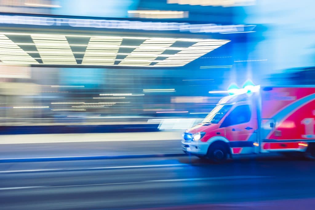 ambulance speeding past buildings