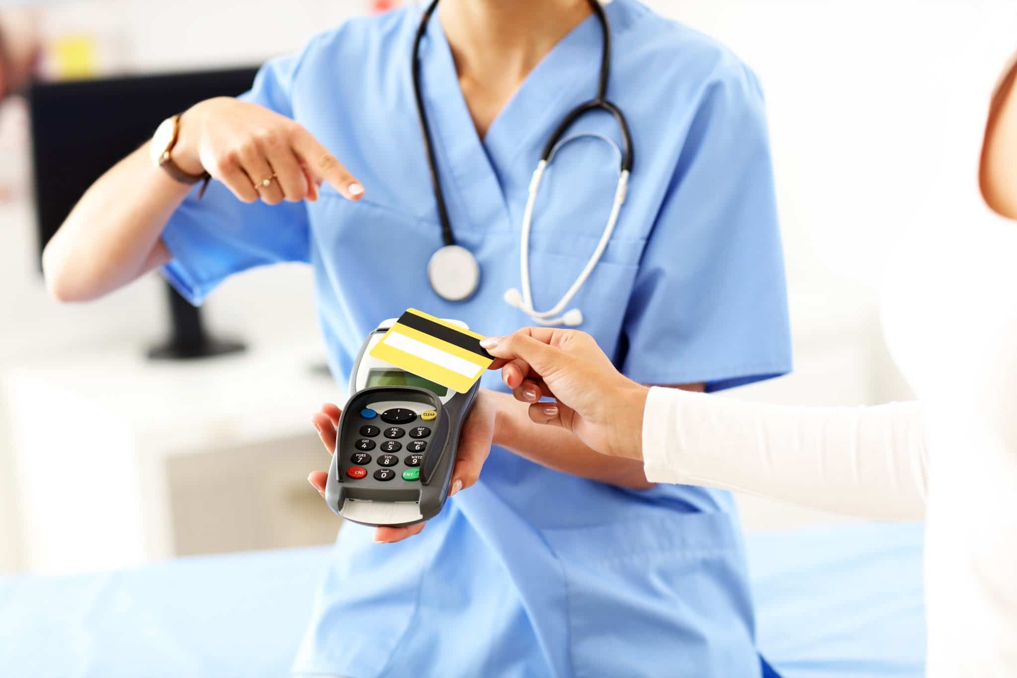 Female nurse accepting credit card payment for medical bills