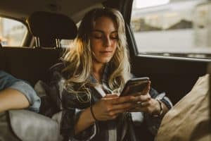 young woman using smartphone while sitting in a car