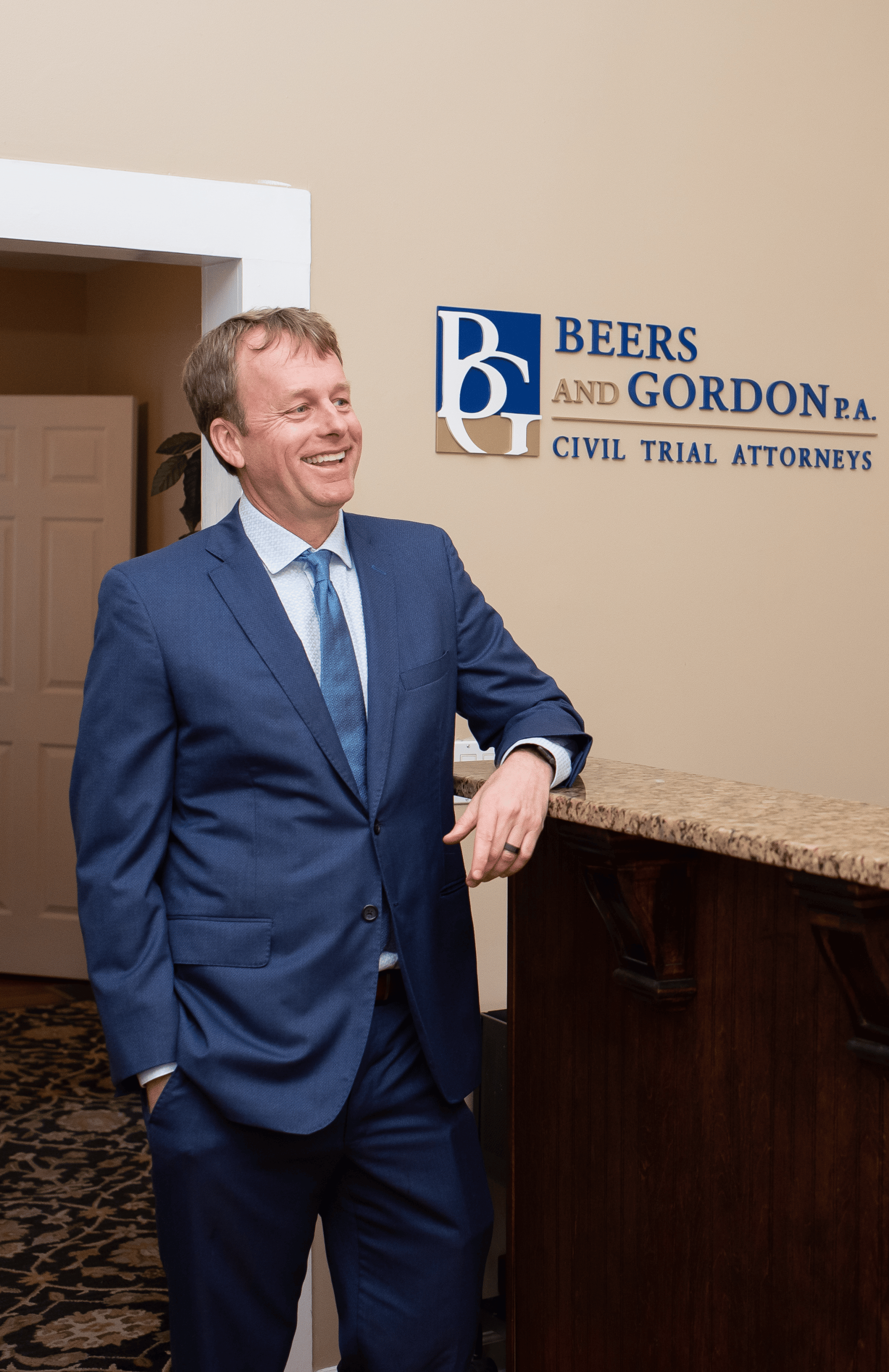 Personal injury attorney Jim Gordon smiling in the lobby of the Beers & Gordon offices.