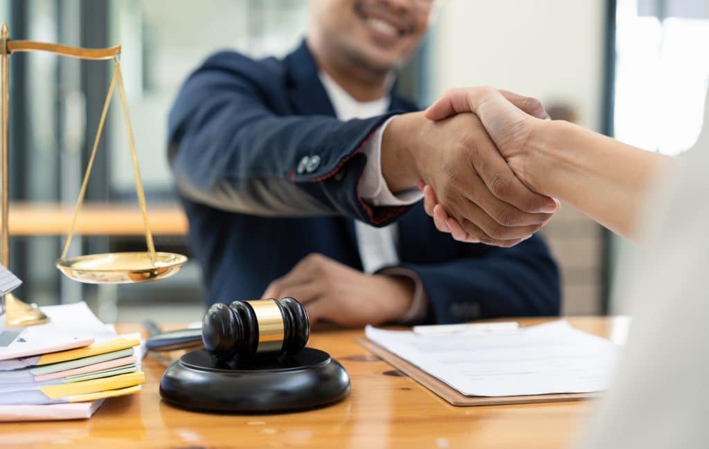 A lawyer shaking hands with a client after a consultation.