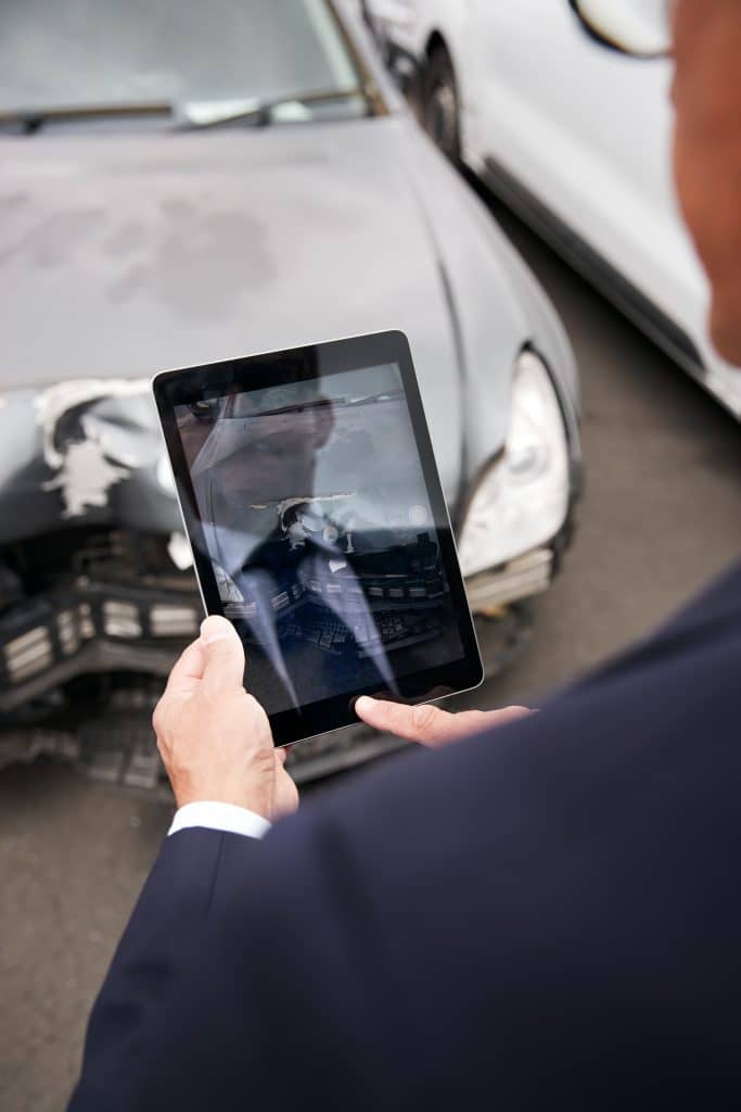 A man taking pictures of his vehicle after a car accident