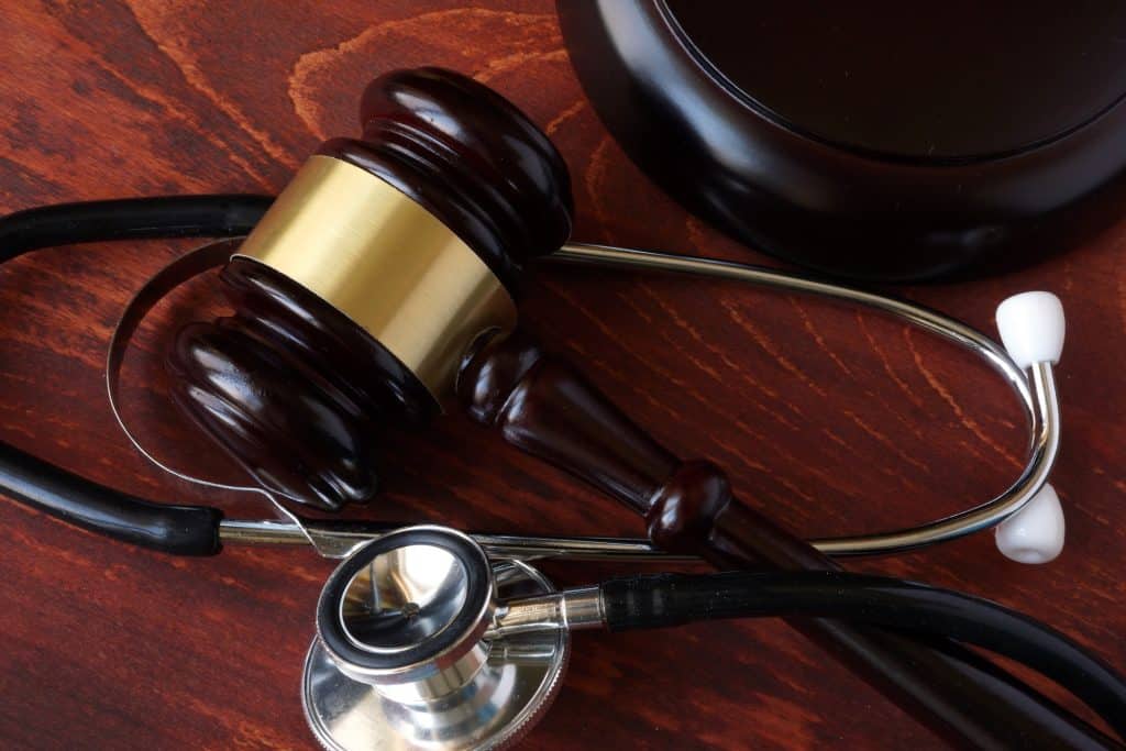 gavel and stethoscope on wooden surface