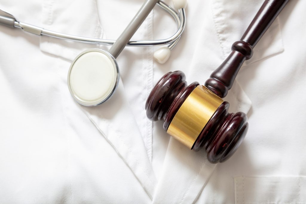A gavel next to a stethoscope, meant to symbolize the healthcare industry and the court system