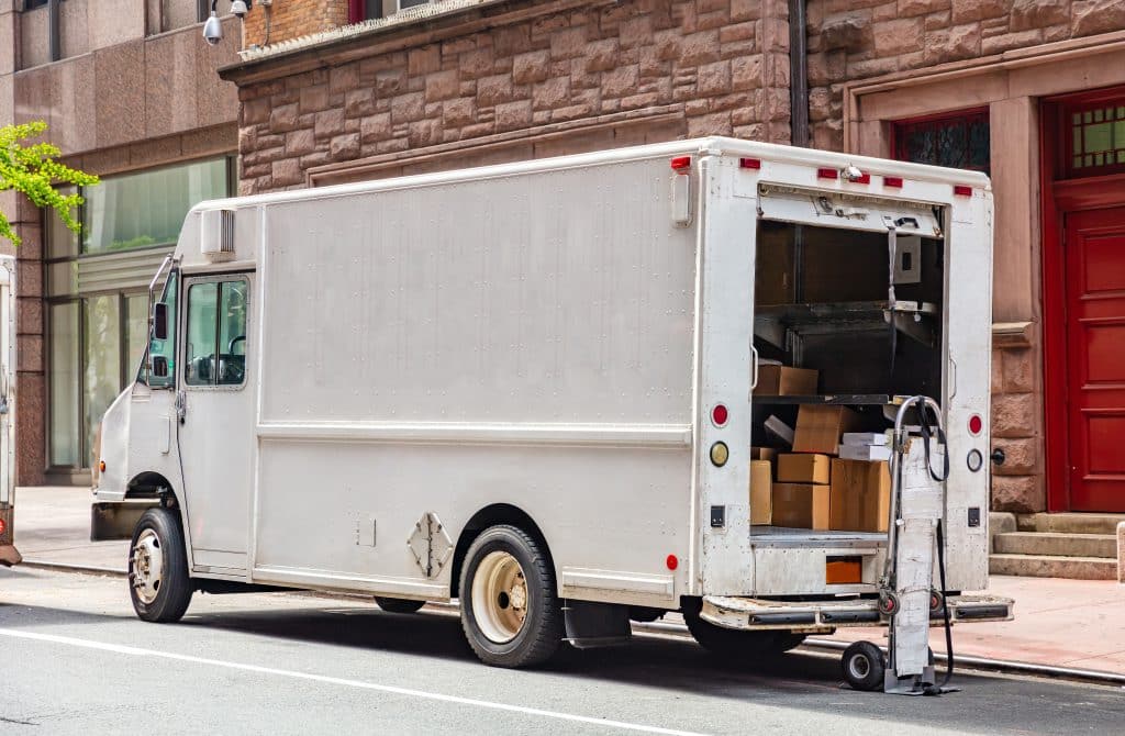 A white commercial truck delivering packages downtown