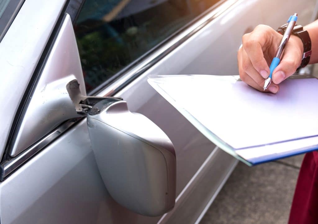 An insurance officer filling out a report after a car accident