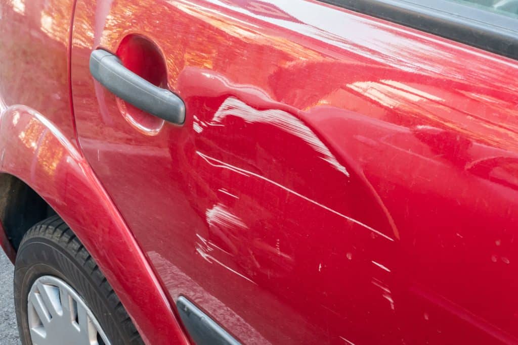 scratches on side door of red car