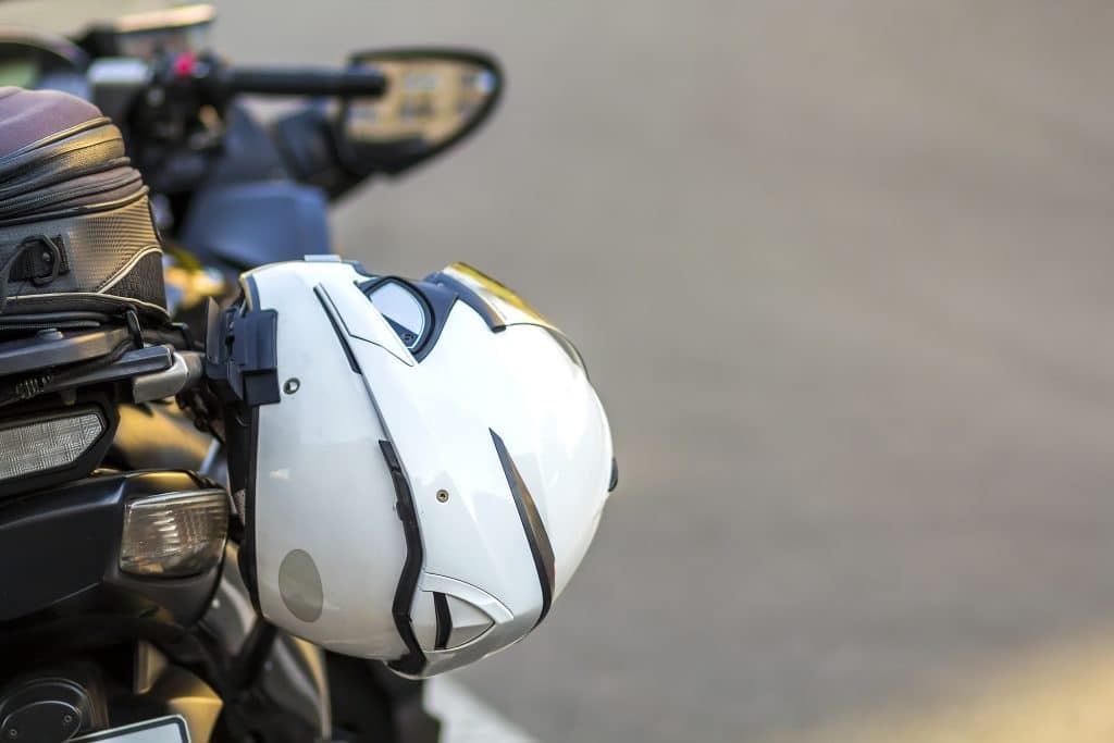 helmet hanging off of motorcycle