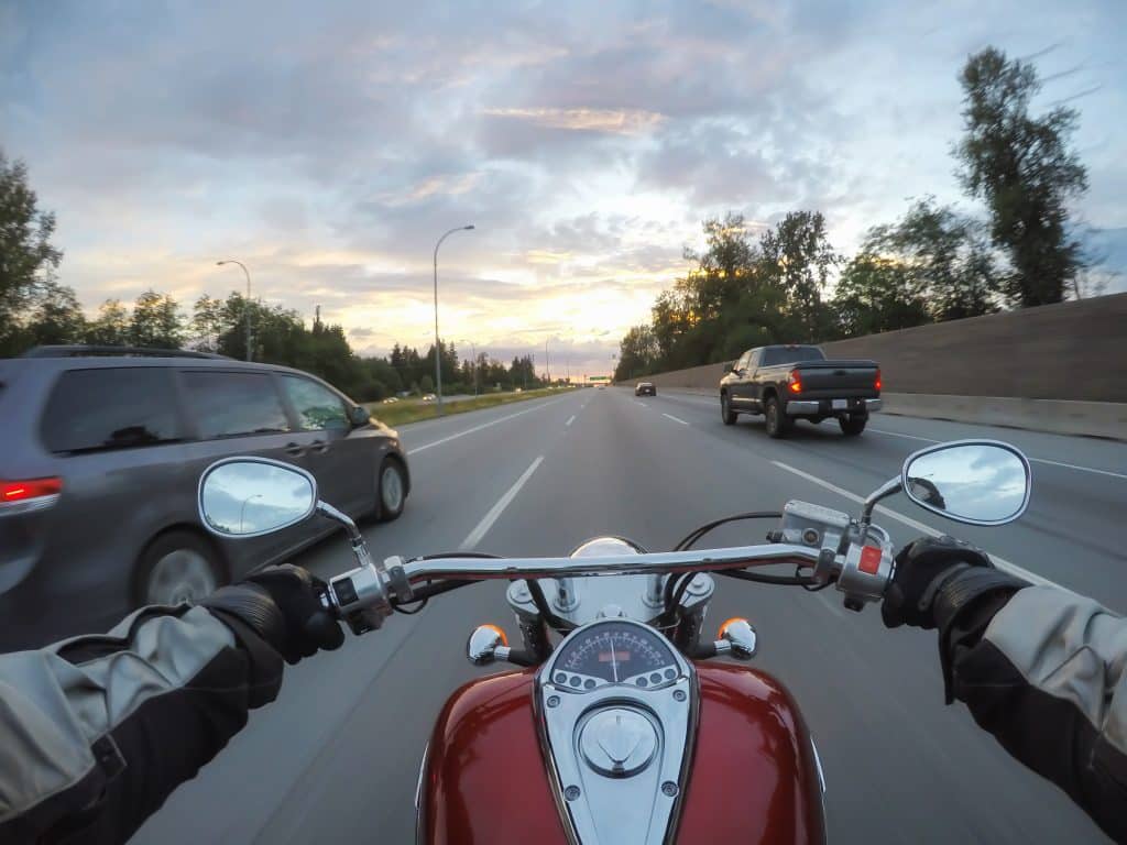 View of motorcycle rider driving down highway