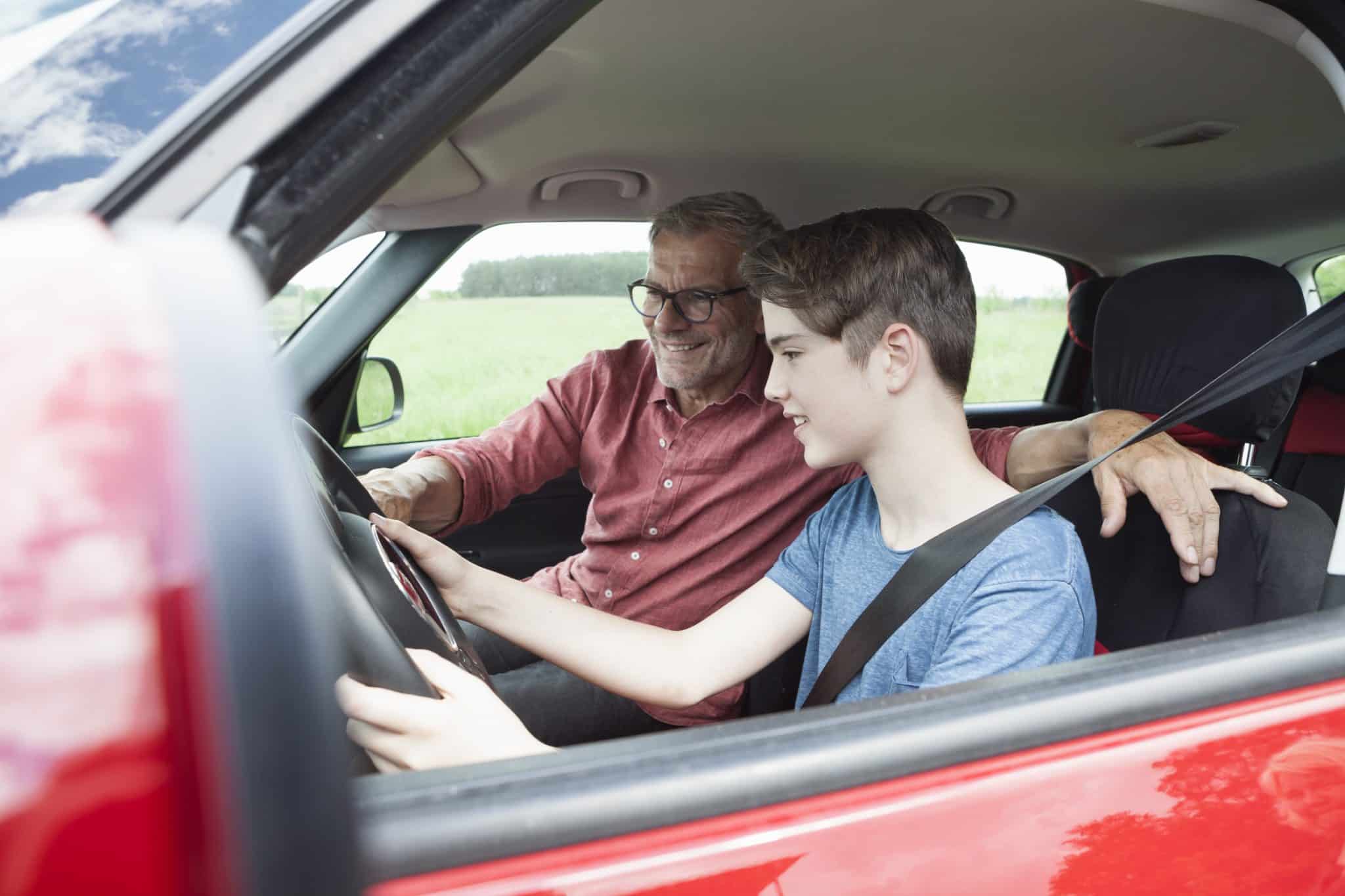 Father teaching son driving a car