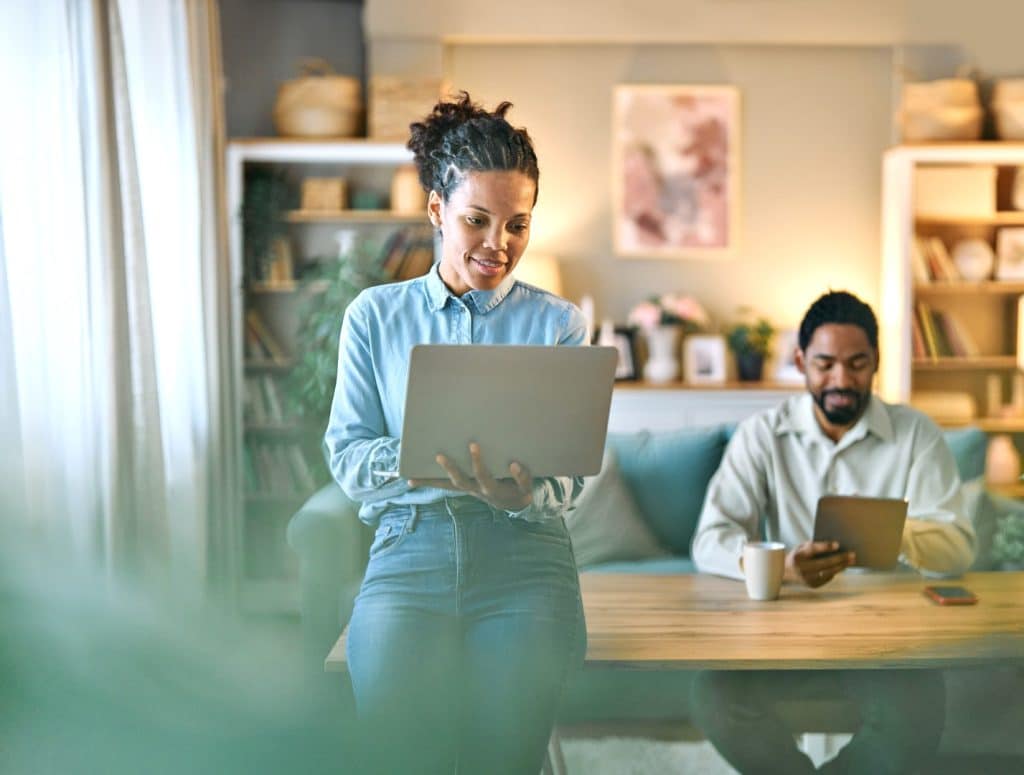 Woman standing while working on laptop in modern office