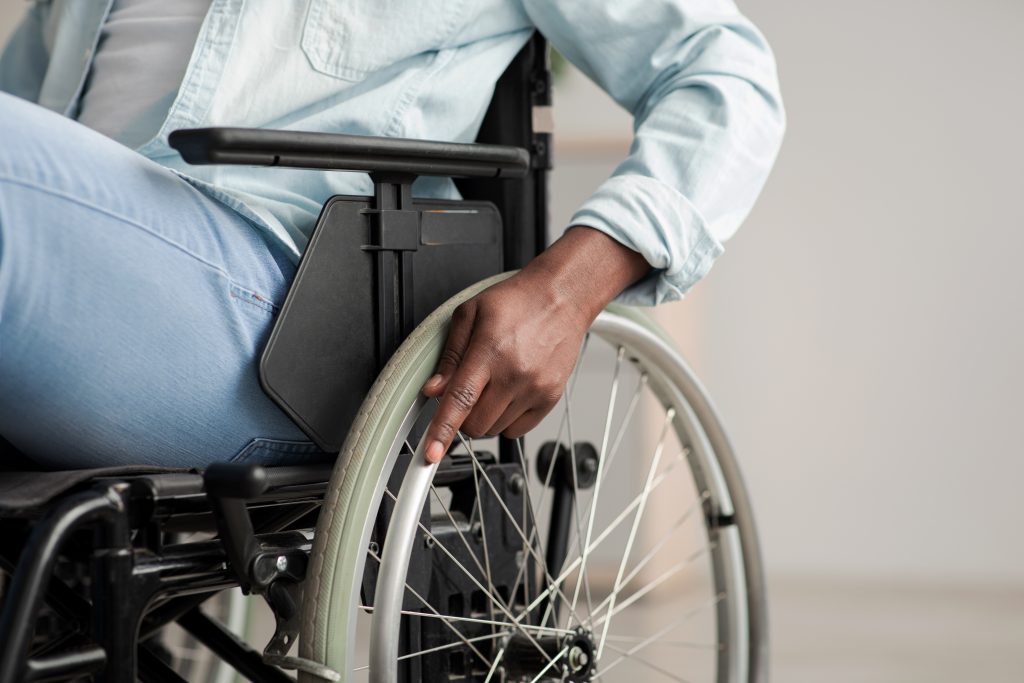 closeup of man in wheelchair with hand on wheel